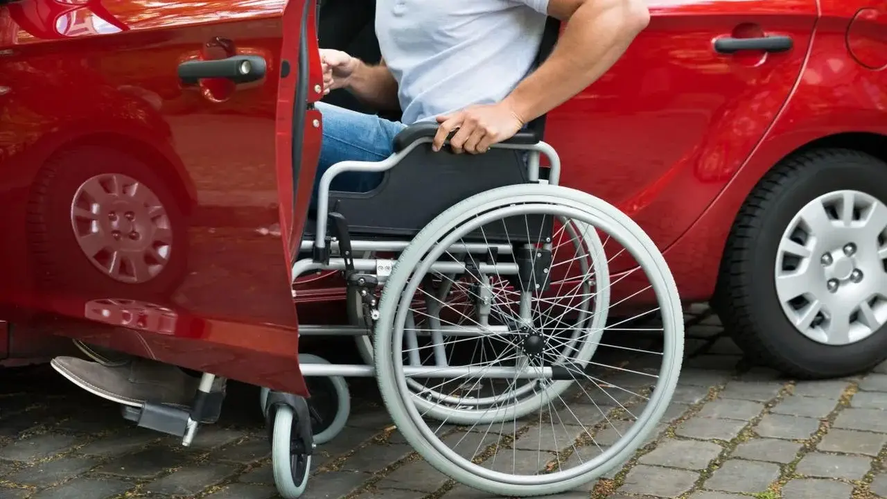 Autista con patente B, in sedia a rotelle, si prepara per la consegna di medicinali.