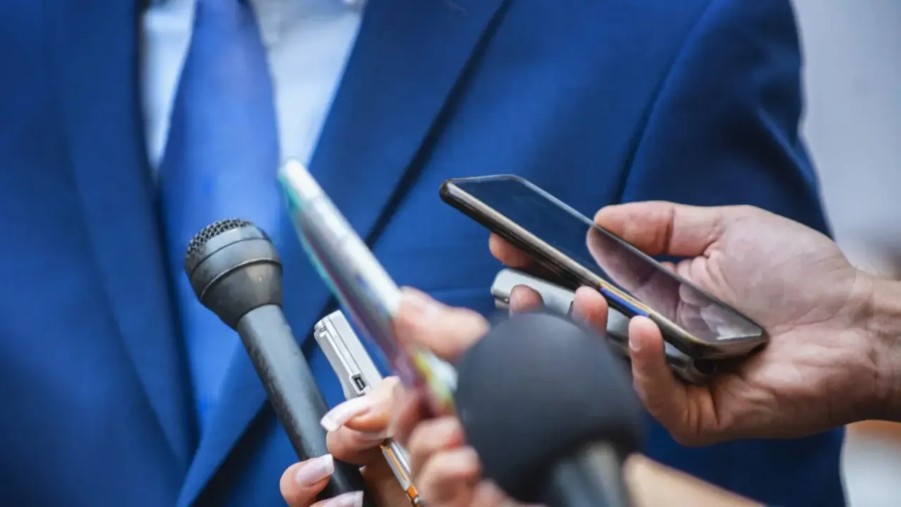 Giornalisti con microfoni e smartphone registrano un'intervista. Chissà quanto guadagna un giornalista oggi?