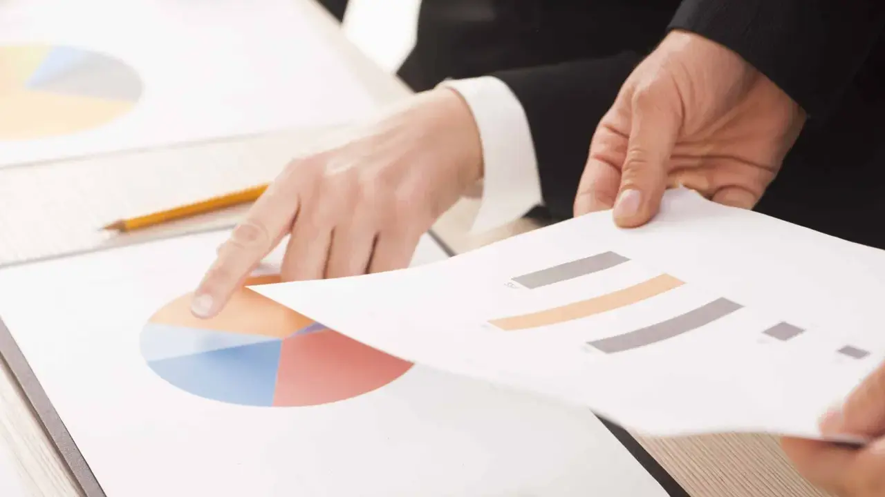 Mani che analizzano grafici, forse per discutere le pause di lavoro previste dal CCNL Commercio.