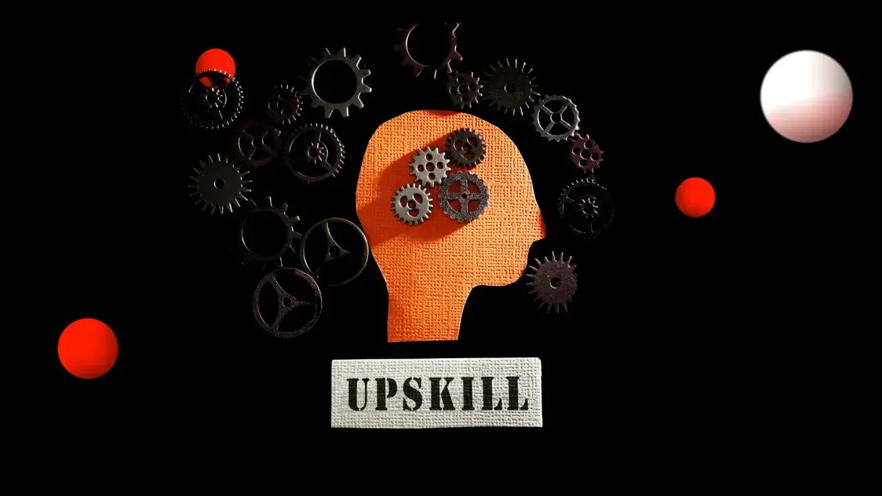 Ingranaggi dentro una testa stilizzata, circondati da altri ingranaggi e sfere rosse. Il concetto di upskilling significato è rappresentato dal movimento e dall'apprendimento continuo.