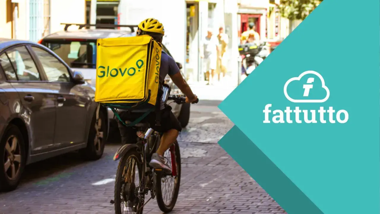 Corriere in bici con zaino giallo Glovo, pronto a consegnare. Scopri come lavorare con Glovo e unisciti alla squadra!