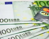 Banconote da 100 euro e una carta di credito, simboli dell'emissione busta paga e dell'accredito stipendio.