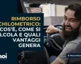 Uomo sorridente al volante, testo su rimborso chilometrico: cos'è, come si calcola e vantaggi.