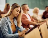 Giovane donna studia su tablet in aula, preparandosi per i concorsi pubblici Molise.