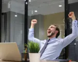 Uomo esulta in ufficio, festeggiando un successo legato alla mobilità pubblica amministrazione.