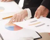 Mani che analizzano grafici, forse per discutere le pause di lavoro previste dal CCNL Commercio.