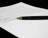 Una penna stilografica nera su un foglio di testo, forse una lettera di richiamo per assenza ingiustificata.