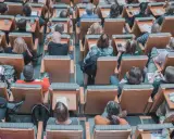 Un pubblico attento in un'aula, molti con quaderni e penne, pronti per nuovi concorsi non scaduti.