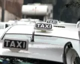 Code di taxi bianchi in attesa, un'immagine che fa riflettere su quanto guadagna un tassista.