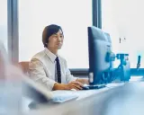 Uomo d'affari al computer, concentrato sul lavoro. Chissà quanto vengono pagati gli straordinari per questo impegno.