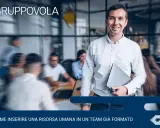 Uomo sorridente con laptop, pronto per l'induction aziendale. Inserire una nuova risorsa in un team è un processo chiave.