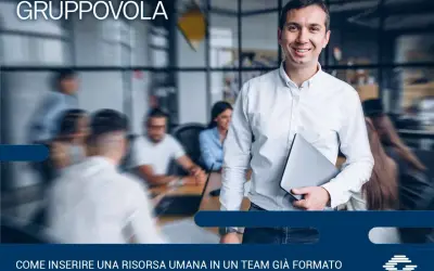 Uomo sorridente con laptop, pronto per l'induction aziendale. Inserire una nuova risorsa in un team è un processo chiave.