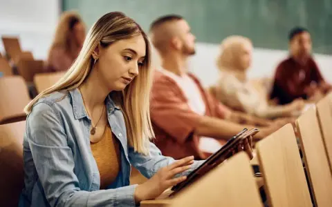 Giovane donna studia su tablet in aula, preparandosi per i concorsi pubblici Molise.