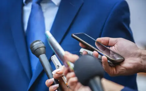 Giornalisti con microfoni e smartphone registrano un'intervista. Chissà quanto guadagna un giornalista oggi?