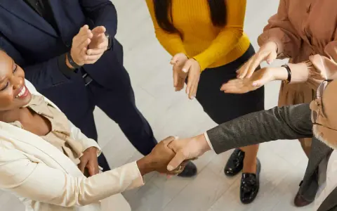 Un gruppo di persone applaude mentre due colleghi si stringono la mano. Un successo che fa ben sperare, anche se il premio produzione può essere tolto.