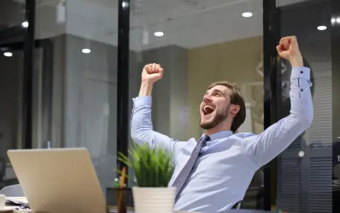 Uomo esulta in ufficio, festeggiando un successo legato alla mobilità pubblica amministrazione.