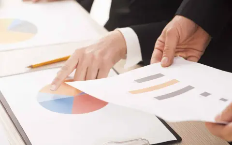 Mani che analizzano grafici, forse per discutere le pause di lavoro previste dal CCNL Commercio.