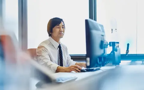 Uomo d'affari al computer, concentrato sul lavoro. Chissà quanto vengono pagati gli straordinari per questo impegno.