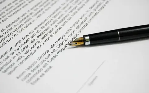 Una penna stilografica su un documento, che ricorda una esempio domanda di trasferimento motivata.