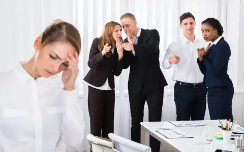 Donna stressata, colleghi che spettegolano e indicano. Come dimostrare il mobbing sul lavoro.