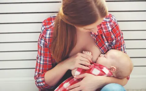 Madre allatta il suo bambino, un momento intimo che spiega le ore di allattamento come funziona.