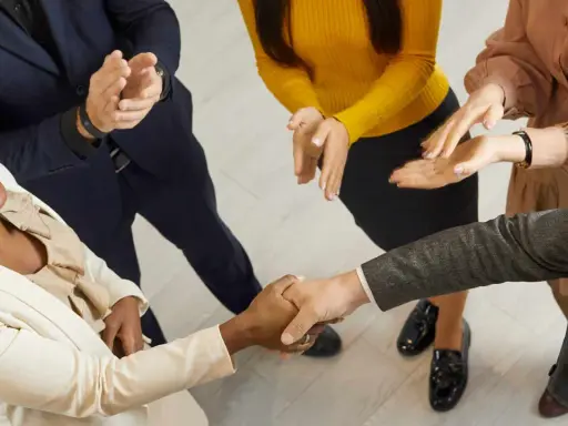 Un gruppo di persone applaude mentre due colleghi si stringono la mano. Un successo che fa ben sperare, anche se il premio produzione può essere tolto.