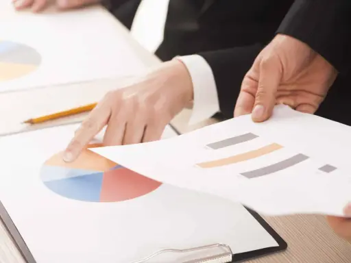 Mani che analizzano grafici, forse per discutere le pause di lavoro previste dal CCNL Commercio.
