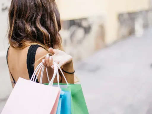 Donna con borse della spesa colorate, felice del suo ruolo di buyer.