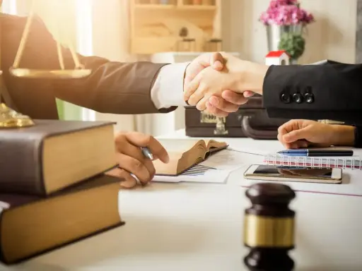 Avvocati si stringono la mano, simboli di giustizia e libri. La domanda "quanto guadagna un avvocato" è al centro di questo accordo.