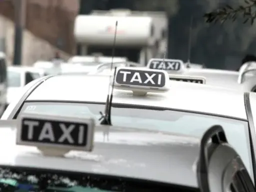 Code di taxi bianchi in attesa, un'immagine che fa riflettere su quanto guadagna un tassista.