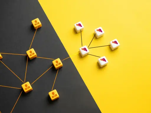 Dadi con icone di persone collegate da fili arancioni, che rappresentano l'outsourcing significato, su sfondo diviso nero e giallo.