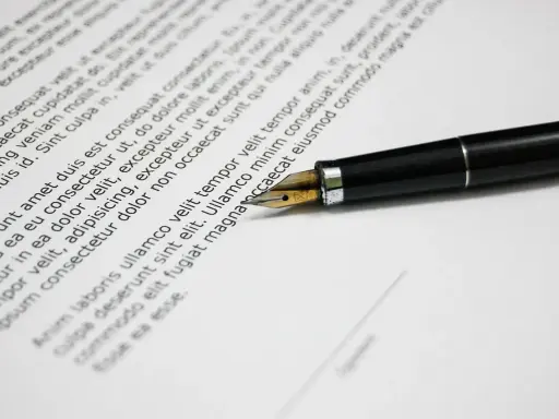 Una penna stilografica su un documento, che ricorda una esempio domanda di trasferimento motivata.