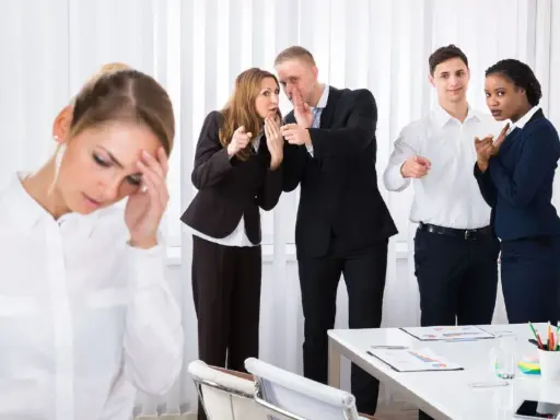 Donna stressata, colleghi che spettegolano e indicano. Come dimostrare il mobbing sul lavoro.