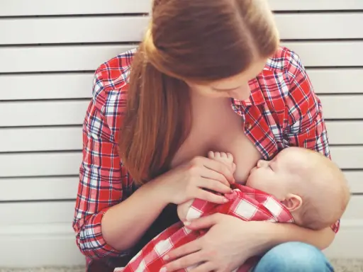 Madre allatta il suo bambino, un momento intimo che spiega le ore di allattamento come funziona.