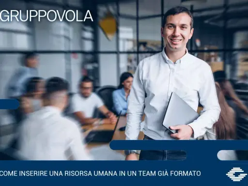 Uomo sorridente con laptop, pronto per l'induction aziendale. Inserire una nuova risorsa in un team è un processo chiave.