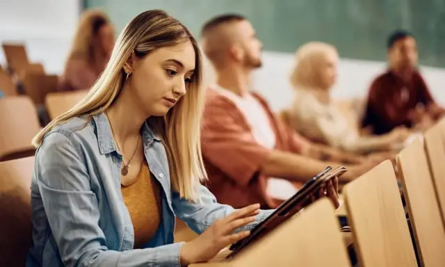 Giovane donna studia su tablet in aula, preparandosi per i concorsi pubblici Molise.