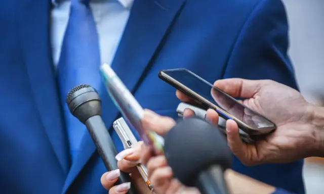 Giornalisti con microfoni e smartphone registrano un'intervista. Chissà quanto guadagna un giornalista oggi?
