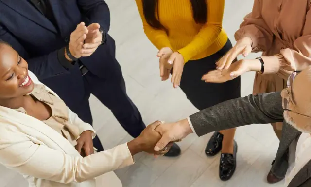 Un gruppo di persone applaude mentre due colleghi si stringono la mano. Un successo che fa ben sperare, anche se il premio produzione può essere tolto.