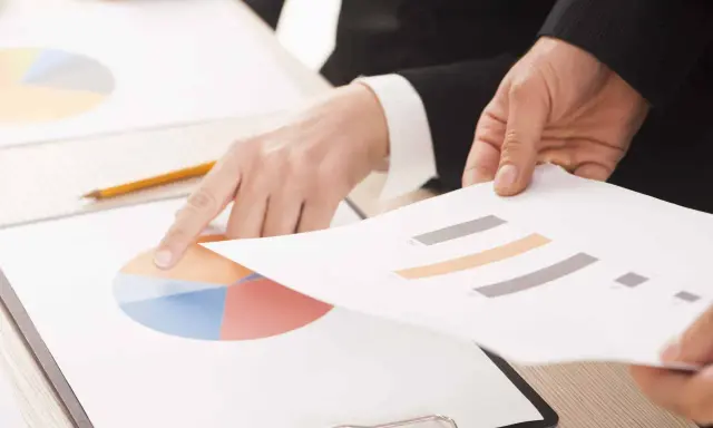 Mani che analizzano grafici, forse per discutere le pause di lavoro previste dal CCNL Commercio.