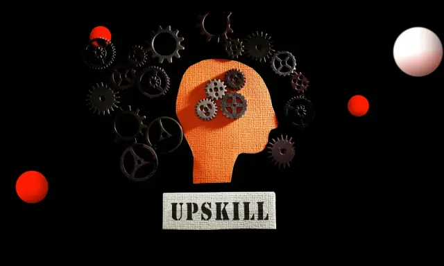 Ingranaggi dentro una testa stilizzata, circondati da altri ingranaggi e sfere rosse. Il concetto di upskilling significato è rappresentato dal movimento e dall'apprendimento continuo.