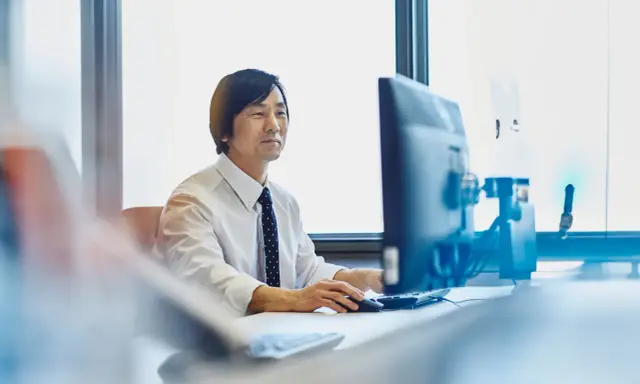 Uomo d'affari al computer, concentrato sul lavoro. Chissà quanto vengono pagati gli straordinari per questo impegno.
