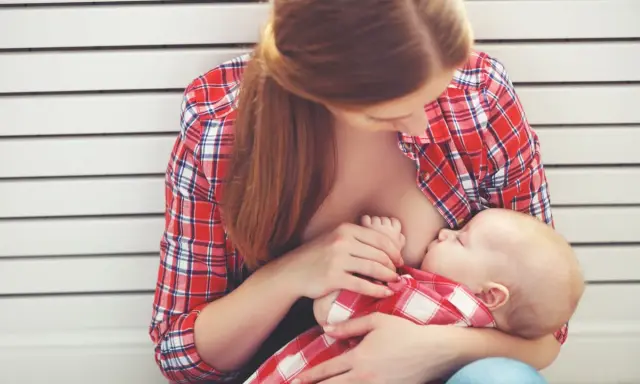 Madre allatta il suo bambino, un momento intimo che spiega le ore di allattamento come funziona.