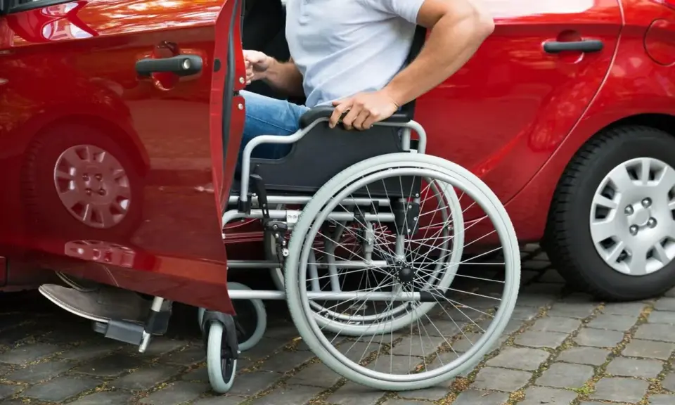 Autista con patente B, in sedia a rotelle, si prepara per la consegna di medicinali.