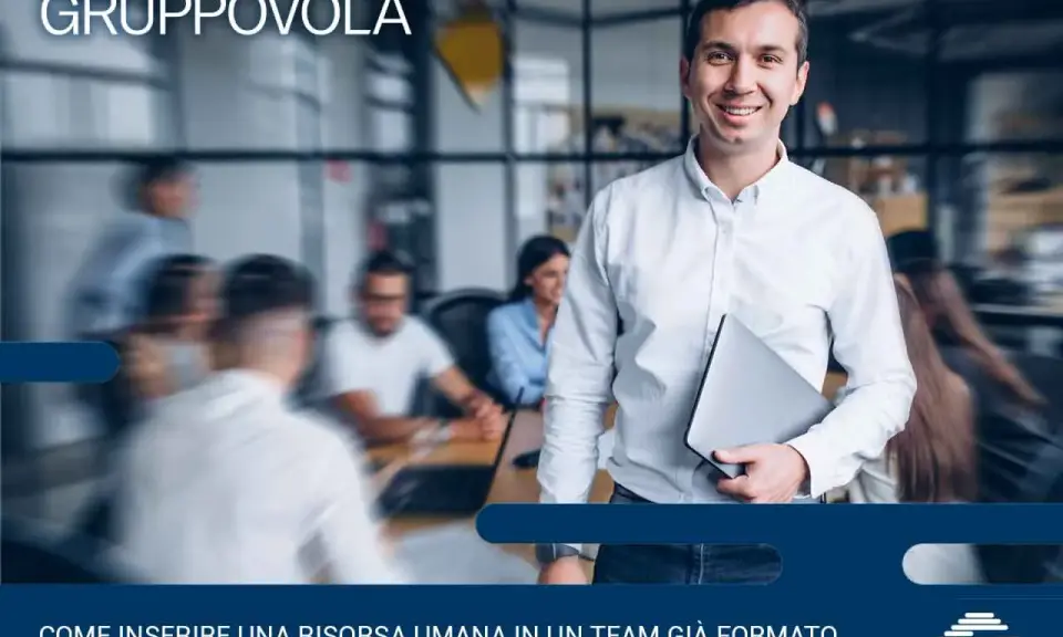 Uomo sorridente con laptop, pronto per l'induction aziendale. Inserire una nuova risorsa in un team è un processo chiave.