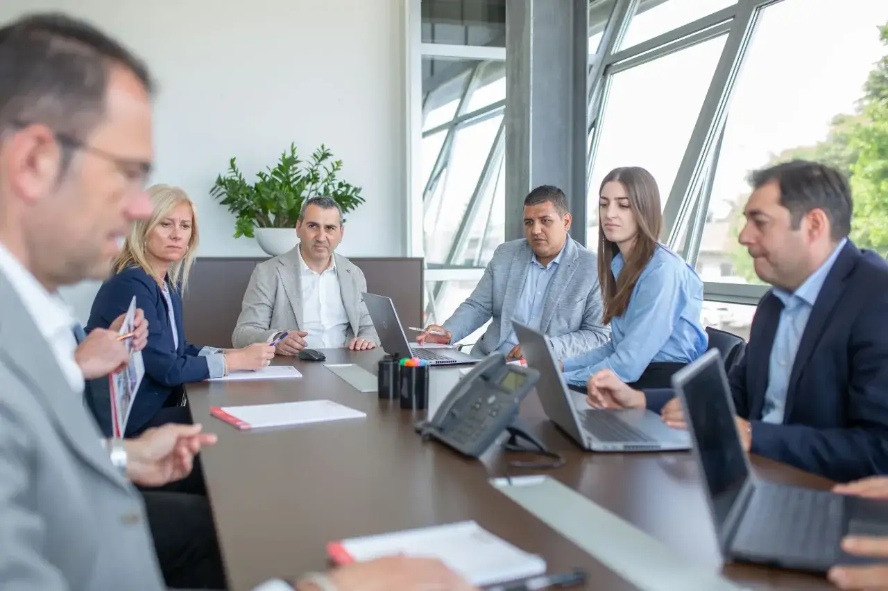 Riunione di team che discute di valori aziendali, esempi concreti di collaborazione e innovazione.