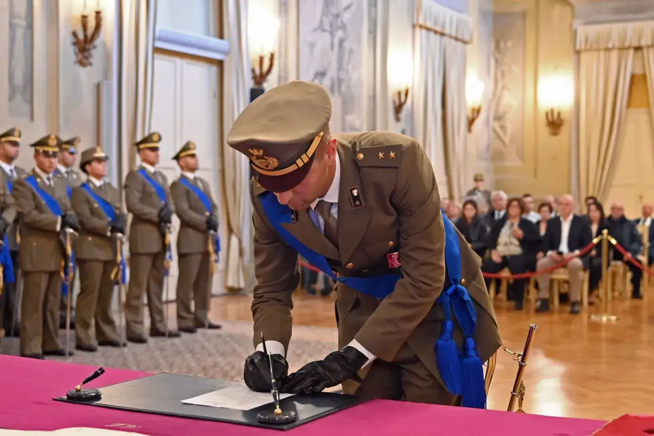 Ufficiale dell'esercito con uniforme storica firma un documento. L'immagine evoca i requisiti per diventare ufficiali a nomina diretta nell'esercito.