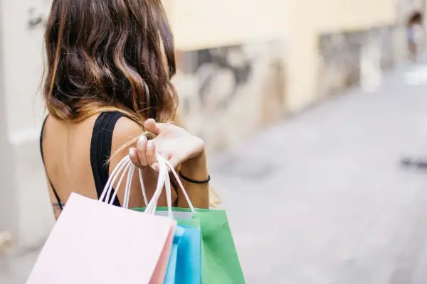Donna con borse della spesa colorate, felice del suo ruolo di buyer.
