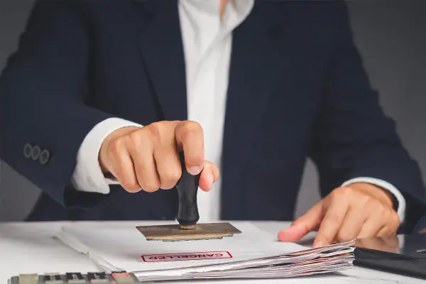 Timbro rosso "CANCELLED" su documenti. I permessi studio possono essere negati, come dimostra questo timbro.