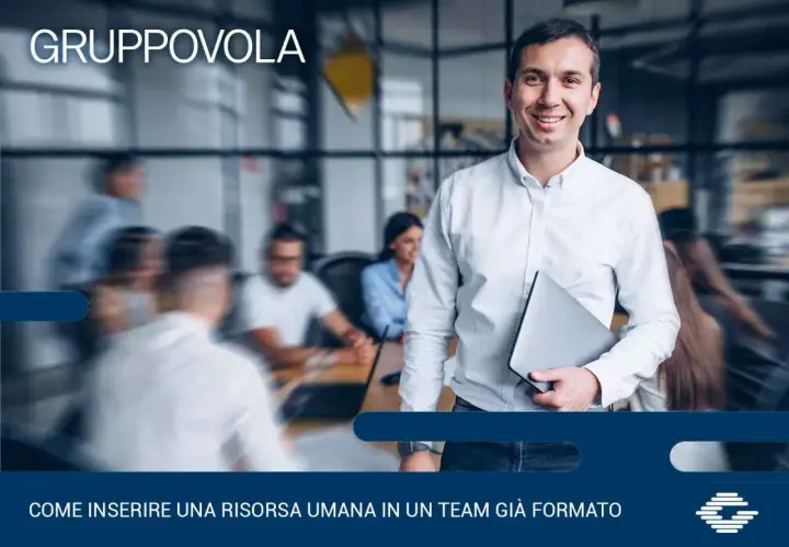Uomo sorridente con laptop, pronto per l'induction aziendale. Inserire una nuova risorsa in un team è un processo chiave.